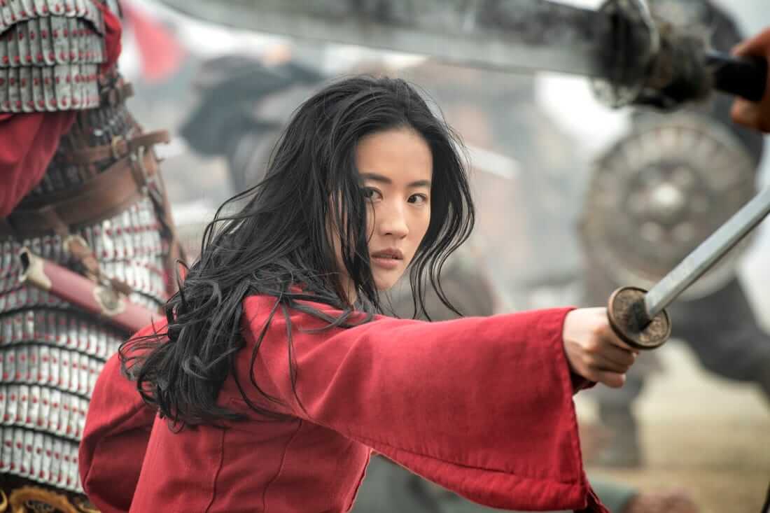 Karakter Mulan diperankan Liu Yifei sedang memegang pedang dengan jubah merah